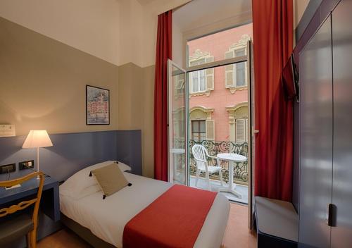 a bedroom with a bed and a balcony with a table at Hotel Italia e Lido Rapallo in Rapallo