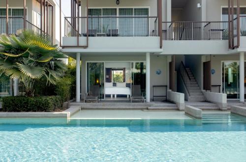 a house with a swimming pool in front of a house at The Waters Khao Lak by Katathani - SHA Extra Plus in Khao Lak