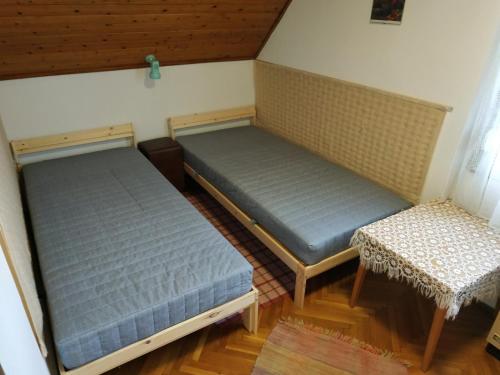 two beds in a room with a table and chairs at Fonyód Nyaraló in Fonyód