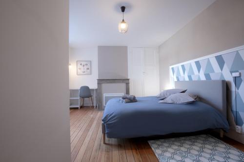 une chambre avec un lit avec un couvre-lit bleu dans l'établissement Résidence Cawikima - Carla House, à Boulogne-sur-Mer