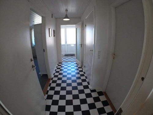 a hallway with a black and white checkered floor at Thy Ferielejlighed in Thisted