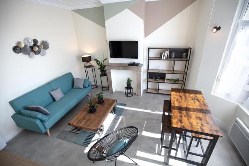 un salon avec un canapé bleu et une table dans l'établissement Résidence Cawikima - Carla House, à Boulogne-sur-Mer