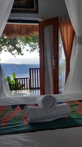 a bedroom with a bed with a view of the ocean at Gamat Garden Homestay in Nusa Penida