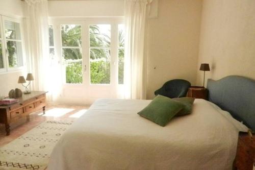 a bedroom with a large bed with a large window at Grande maison au cadre verdoyant au centre village in Cargèse
