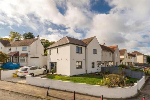 a white house with a car parked in a yard at Dreghorn House - 10 Beds 2,5 Ba - Private Parking - Free Wifi in Edinburgh