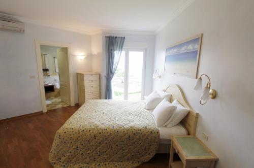a bedroom with a bed and a table and a window at Luxury apartment Pelargonija in Monterosso Resort in Savudrija