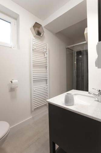 une salle de bain blanche avec un lavabo et des toilettes dans l'établissement Résidence Cawikima - Willis Home, à Boulogne-sur-Mer