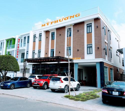 ラックザーにあるHotel Mỹ Phươngの駐車場に車が駐車されている建物