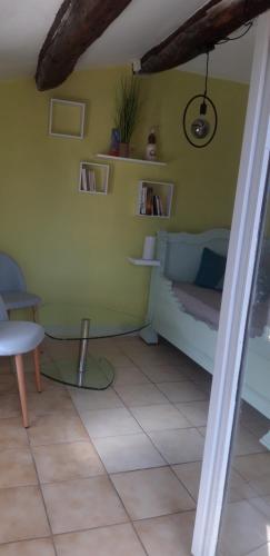 a room with a green wall with a bed and a table at Gîtes chez Daniel "Cevennes 2" in Mars