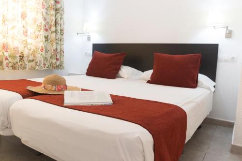 2 łóżka w pokoju hotelowym z kapeluszem w obiekcie Alsol Mariachis w mieście Playa del Ingles