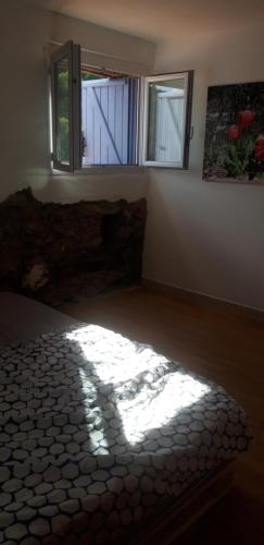 a room with a bed and a window and a rug at Gîtes chez Daniel "Cevennes 2" in Mars