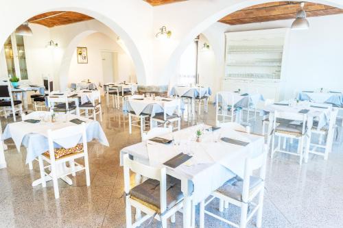 a dining room with white tables and chairs at Hotel The Flash - Venturina Terme in Venturina Terme