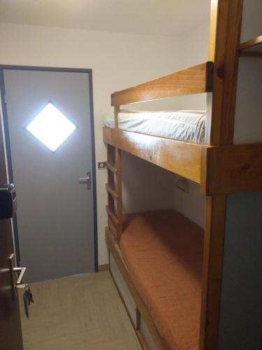 a room with two bunk beds and a door at La Voile - Pendine 2 - Puy Saint Vincent - Hautes Alpes in Puy-Saint-Vincent