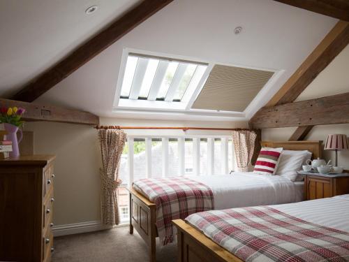 a attic bedroom with two beds and a skylight at Oliver Cromwell in Winchcombe
