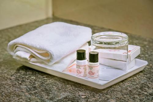 a tray with two bottles of cosmetics and a towel at Hotel Hira Inn-10mins From Railway Station & Bus Station in Allahābād