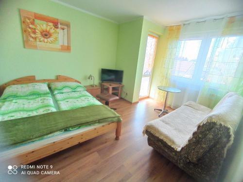 1 dormitorio con 1 cama y 1 silla en Arkona, en Dziwnówek