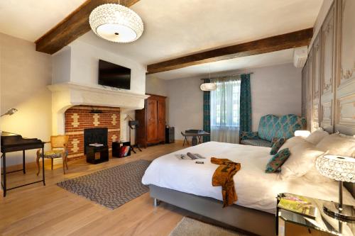 
a living room with a large bed and a fireplace at Château de Melin - B&B in Auxey-Duresses
