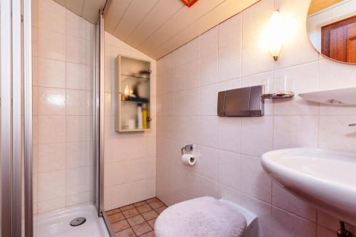 ein weißes Bad mit einem Waschbecken und einem WC in der Unterkunft Haus Sonneck Ferienwohnungen GbR in Reit im Winkl