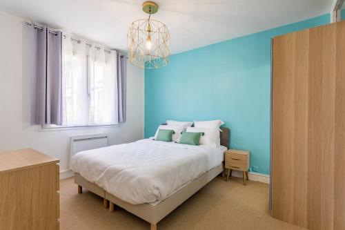 une chambre avec un grand lit avec un mur bleu dans l'établissement Maison Morny, à Deauville