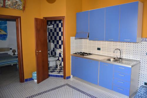 una cocina con armarios azules y fregadero en Le Soleil B&B, en Milazzo