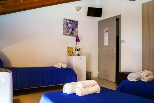 two beds in a room with blue sheets and towels at Sansi´s Sapri Camere in Sapri