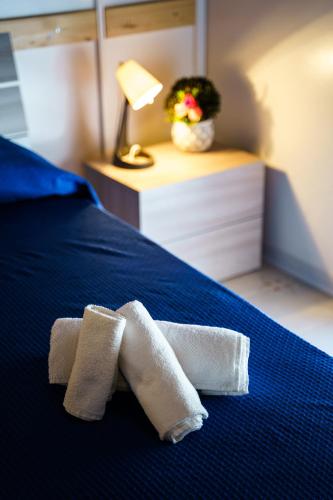two towels on a bed with a lamp and a plant at Sansi´s Sapri Camere in Sapri