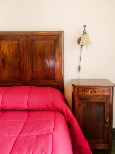 a bedroom with a red bed and a wooden cabinet at Il Mulino in Locri