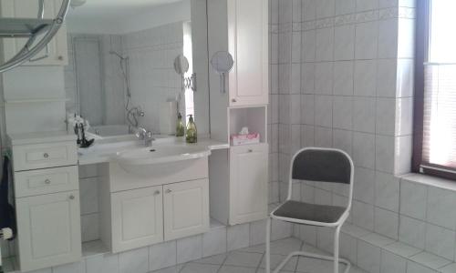 a bathroom with a sink and a chair in it at Ferienhaus - Roggentin in Roggentin