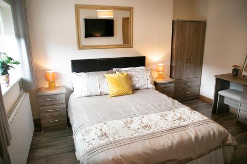 a bedroom with a bed with a yellow pillow on it at Arch House Apartments in Athlone