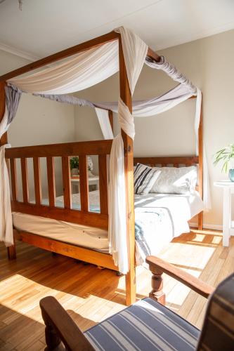 a bedroom with a canopy bed in a room at Wilderness Beach House Backpackers Lodge in Wilderness