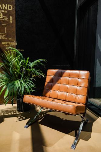 a brown leather chair sitting next to a plant at 24Seven Hotel Schwabach in Schwabach