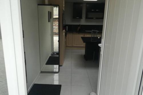 a view of a kitchen with a mirror in the doorway at Appartement neuf à Boussu - Près de la France - Séjour Détente in Boussu
