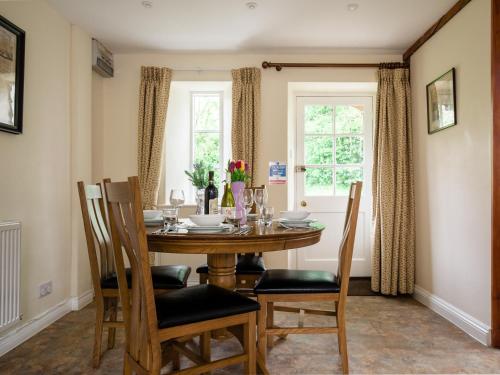 Un comedor con mesa y sillas y una ventana. en Prince Rupert, en Winchcombe