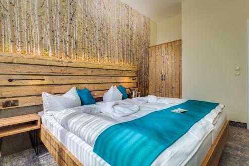 a bedroom with a large bed with a wooden headboard at Panorama Ferien Hotel Harz in Güntersberge