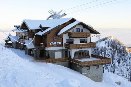 um edifício no topo de uma montanha coberta de neve em Yager Chalet em Poiana Brasov