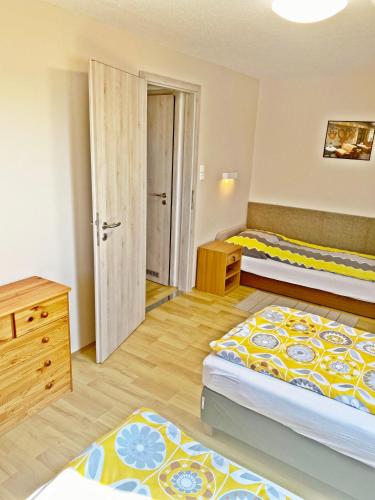 a bedroom with two beds and a dresser at Fured Apartments in Balatonfüred