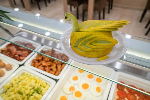 a yellow banana sitting on a plate on a display case at Denise Beach Hotel in Laganas