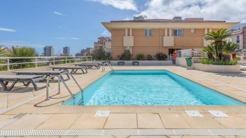 une piscine avec des tables de pique-nique et un bâtiment dans l'établissement Luxury studio renovated 2024 with free parking, à Beausoleil