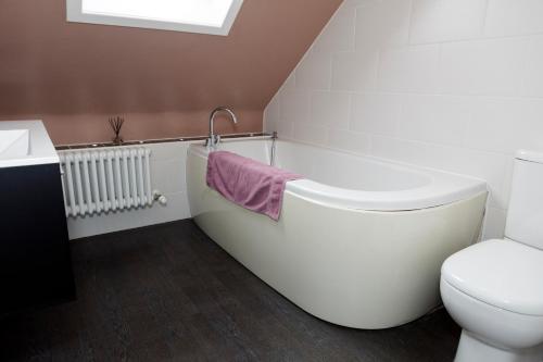 een badkamer met een bad, een toilet en een wastafel bij The Dragonfly in Stornoway