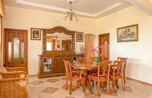 a dining room with a table and chairs and a mirror at SeyBreeze Villa in Anse Royale