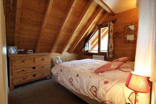 une chambre avec un lit dans une cabane en bois dans l'établissement VAUJANYLOCATIONS - Le Grenier de Germaine, à Vaujany