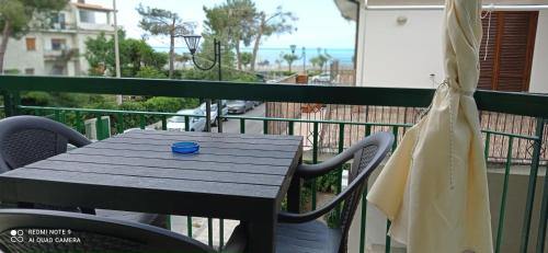 a table on a balcony with a blue cup on it at AD UN PASSO DAL MARE in Praia a Mare