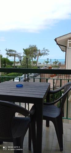 a wooden table and chairs on a balcony at AD UN PASSO DAL MARE in Praia a Mare