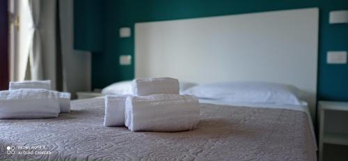 a pile of towels sitting on top of a bed at AD UN PASSO DAL MARE in Praia a Mare