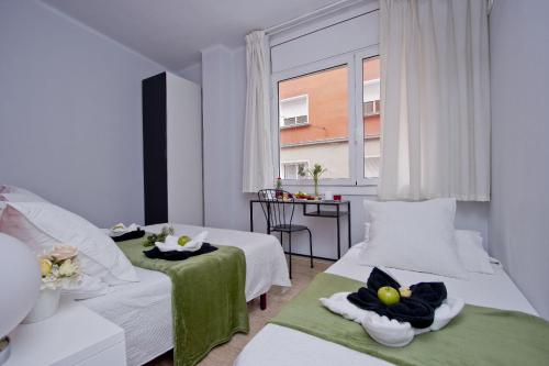 a hotel room with two beds and a window at Barcelona City North Hostal in Barcelona