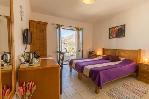 a bedroom with a bed and a desk and a window at Castelletto in Cavtat