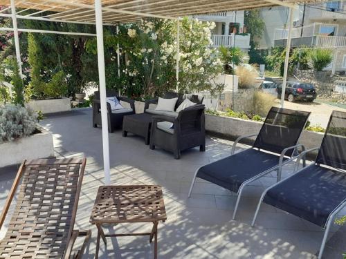 a patio with chairs and tables and an umbrella at Castelletto in Cavtat