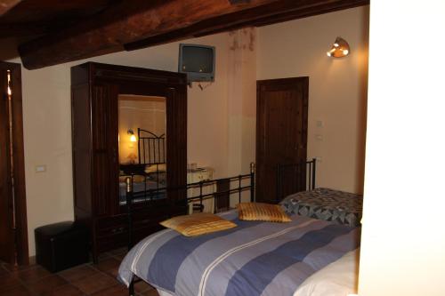 a bedroom with two beds and a tv on the wall at Agriturismo Capriccio Di Giove in Cansano