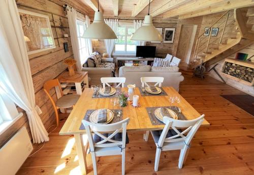 comedor y sala de estar con mesa de madera y sillas en Vidugiris Lake, 