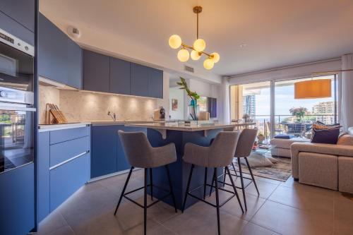 eine Küche mit blauen Schränken und Barhockern in der Unterkunft Monaco à pied in Beausoleil